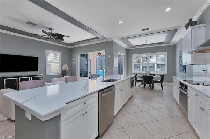 Kitchen with visible vents, a sink, stainless steel appliances, crown molding, and a raised ceiling