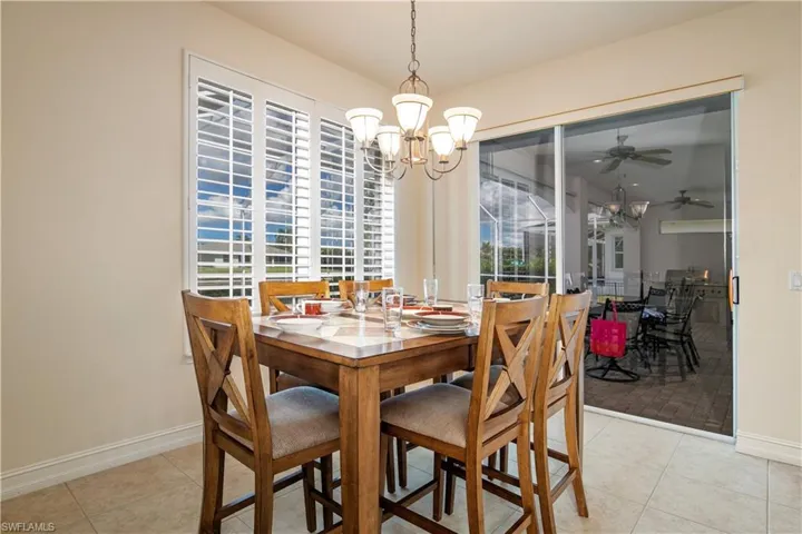 View of Family Dining with Plantation Shutter and Slier to Lanai Under Truss and Pool Deck