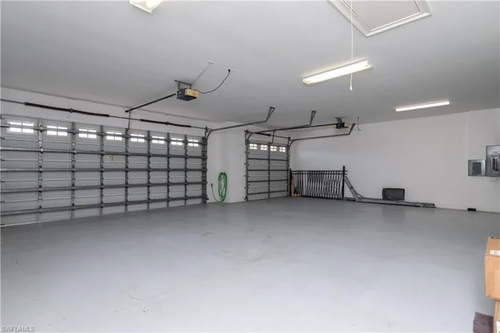 View of the HUGE Three Car Garage.  The Single Bay has its Garage Extension to Storage and Rear Garage Doorway to A/C equipment etc.  All are remote garage door openers.
