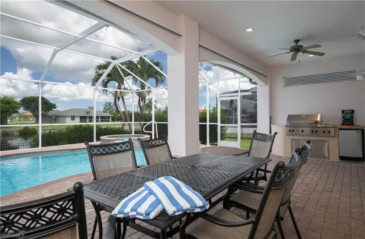 View of Paver Deck Pool/Spa with paver lengthy Lanai Dining and Outdoor Kitchen... all under Truss to enjoy dining under truss view the Cape's outstanding sunsets plus!