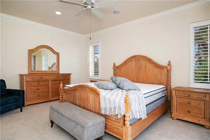View of sunlit Primary-2/Ensuite with Plantation Shutters, Walk In Closet, Bath w/Walk In Shower, Toilet Closet and Slider to Second Master Deck Seating and Dining