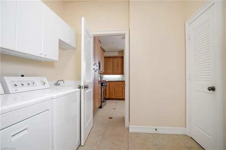 A Utility Room to die for with W/D, Over Appliance Cabinetry, Great Shelved Utility/Pantry Closet and Fold/Store Ironing Board located between Kitchen and Three-Car Garage