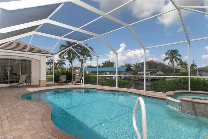 View of Crystal Clear HEATED Pool/Spa, Paver Deck, Screen Cage, Master-2 Seating Under Truss [see Captain Walk Canopy Boat Lift]