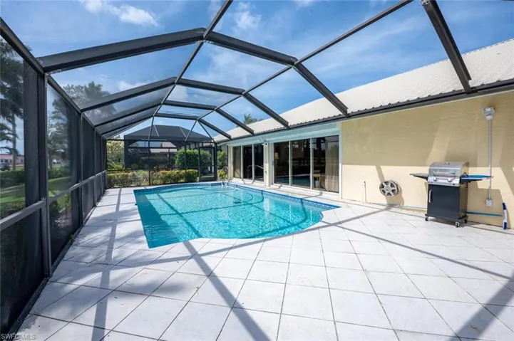 Outdoor pool featuring grilling area, a lanai, and a patio area