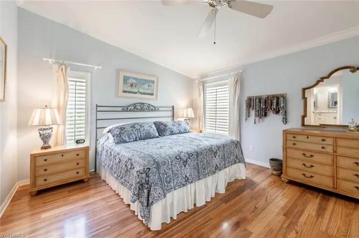 Bedroom featuring multiple windows, light wood-style flooring, and crown molding