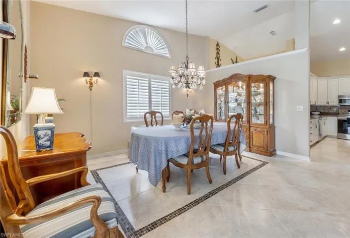 Dining area featuring visible vents, high vaulted ceiling, a notable chandelier, and light tile patterned floors