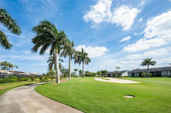 View of property's community featuring a lawn, view of golf course, and a residential view