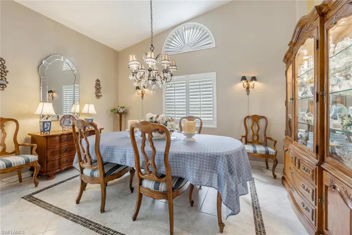 Dining room featuring high vaulted ceiling, a chandelier, and light tile patterned floors