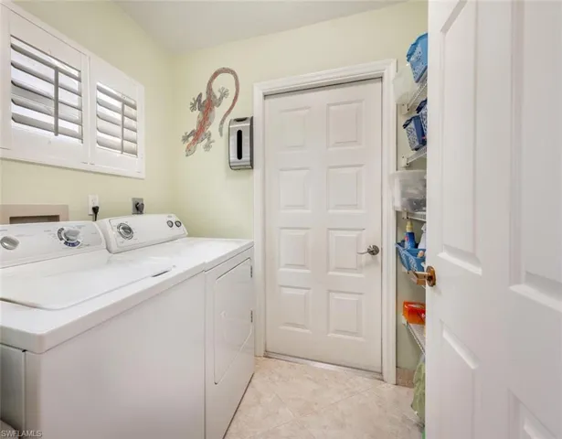 Laundry area with light tile patterned floors, separate washer and dryer, and laundry area