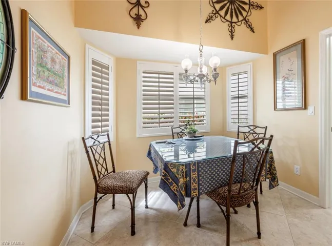 Dining room with baseboards, a chandelier, and light tile patterned floors