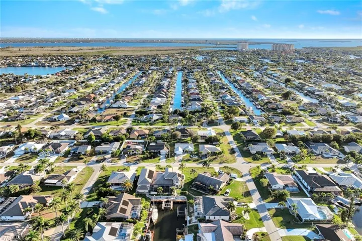 Aerial view of property and surrounding area with a large body of water and nearby suburban area