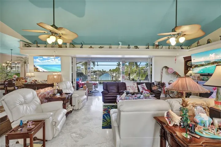 Living room with a ceiling fan and vaulted ceiling