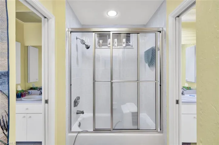 Full bathroom featuring vanity and bath / shower combo with glass door