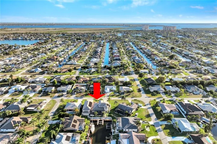 Aerial view of property's location with a large body of water and nearby suburban area