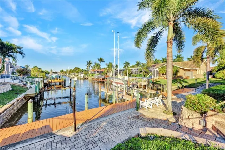 Dock area with boat lift, a water view, and a residential view