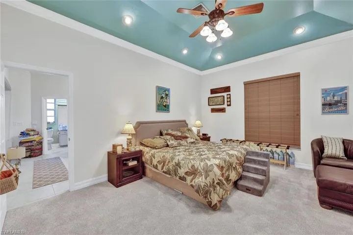 Carpeted bedroom with ornamental molding, a ceiling fan, and recessed lighting