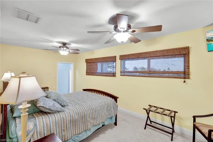Carpeted bedroom featuring a ceiling fan and baseboards