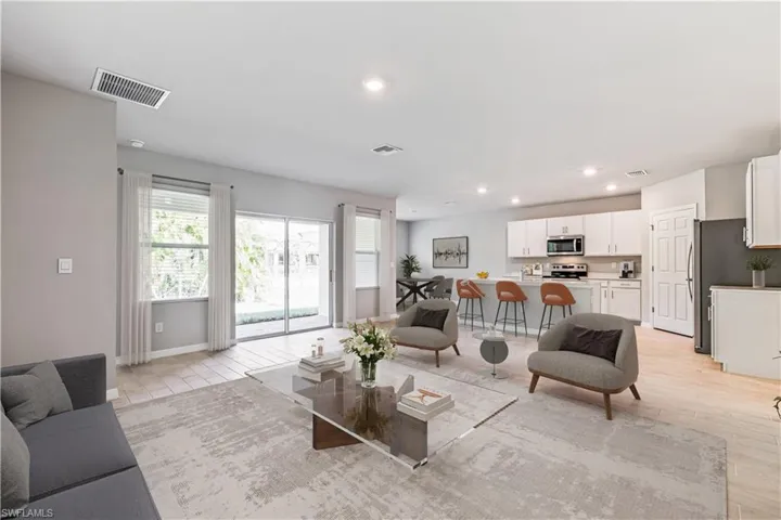 This image is virtually staged. Living area with recessed lighting and baseboards