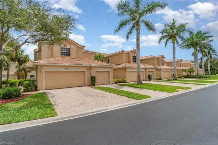 Mediterranean / spanish house with stucco siding, decorative driveway, a yard, and a tile roof