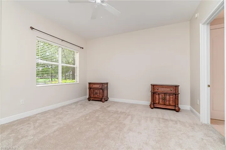Walk in closet with light colored carpet - Primary Bedroom
