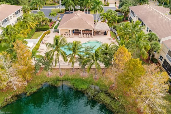 Aerial view of property and surrounding area featuring a pool and a nearby body of water