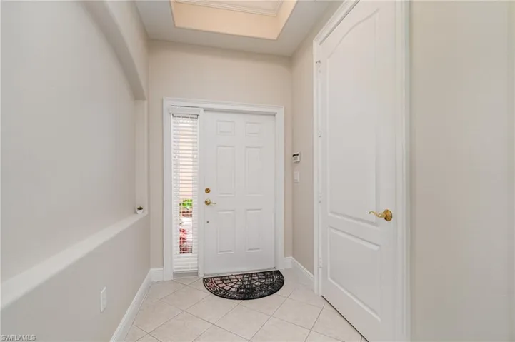 Formal dining area featuring a tray ceiling, a chandelier, dark tile patterned floors, and crown molding