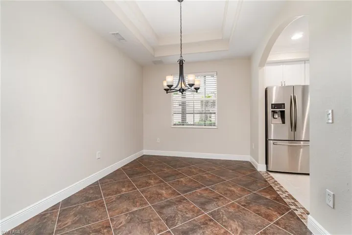 Dining area with a chandelier, crown molding, and light tile patterned floors