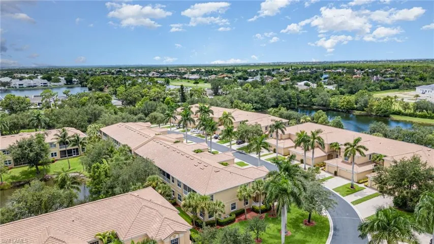 Aerial view of residential area featuring a nearby body of water and a tree filled landscape