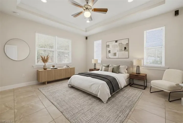 Spacious room featuring a tray ceiling with a ceiling fan, recessed lighting, and tile flooring