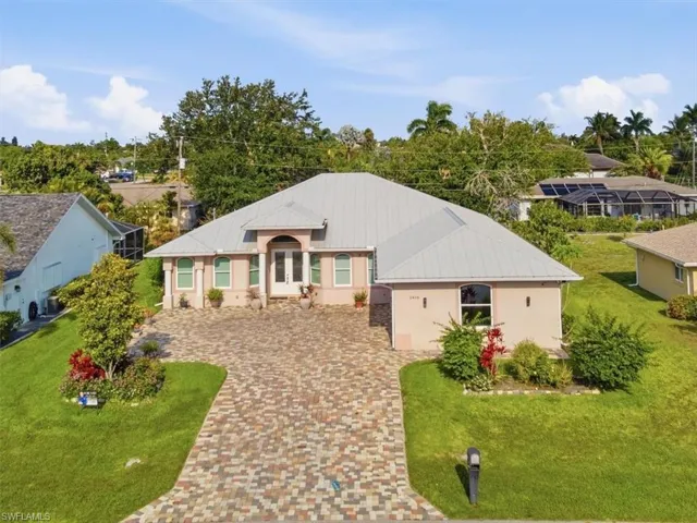 Contemporary residence with a metal roof and an arched double-door entry