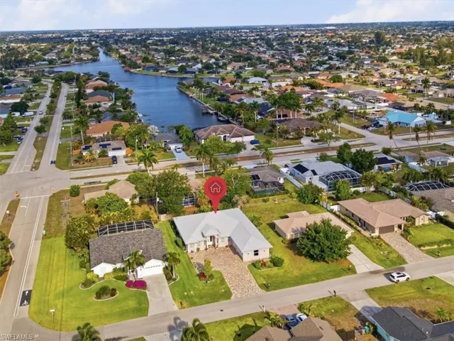 Aerial perspective showcasing a canal-front community with a prominent single-story residence