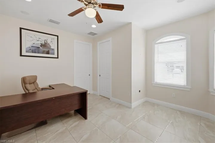Spacious room featuring neutral-toned walls and large format tile flooring