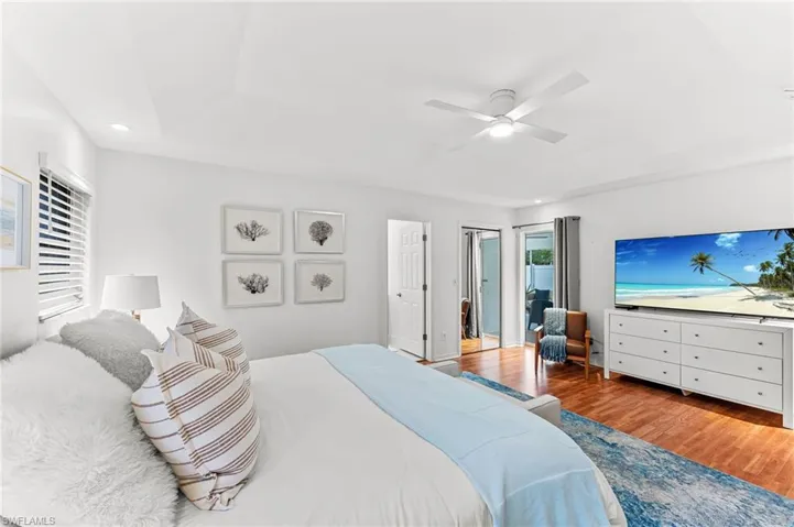 Bedroom featuring wood finished floors, ceiling fan, recessed lighting, and a raised ceiling
