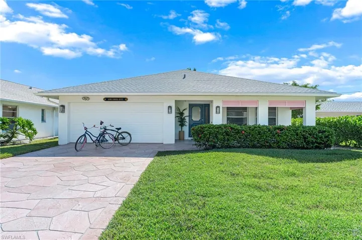 Ranch-style house featuring a front lawn, driveway, stucco siding, a shingled roof, and a garage