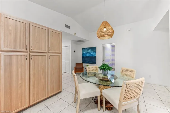 Dining space with vaulted ceiling and light tile patterned floors