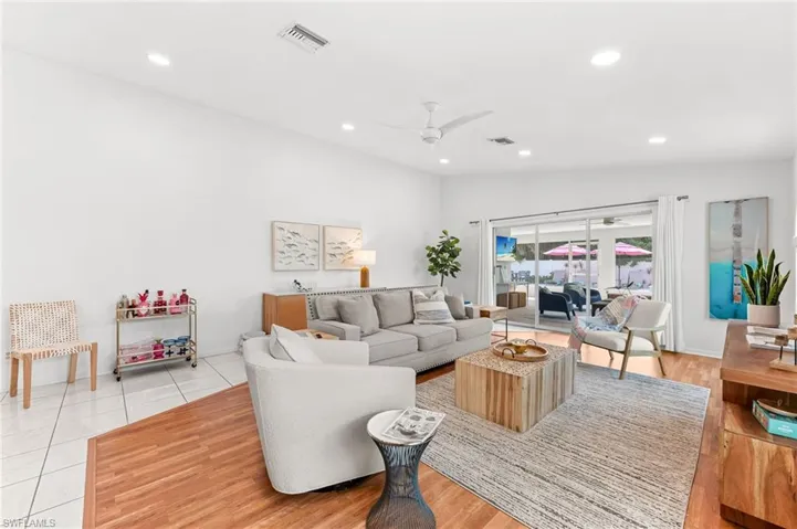 Living room with vaulted ceiling, a ceiling fan, and recessed lighting