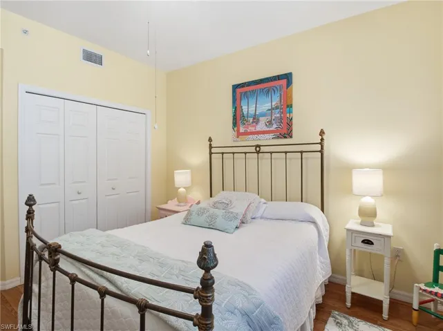 Bedroom with a closet and dark wood-style floors