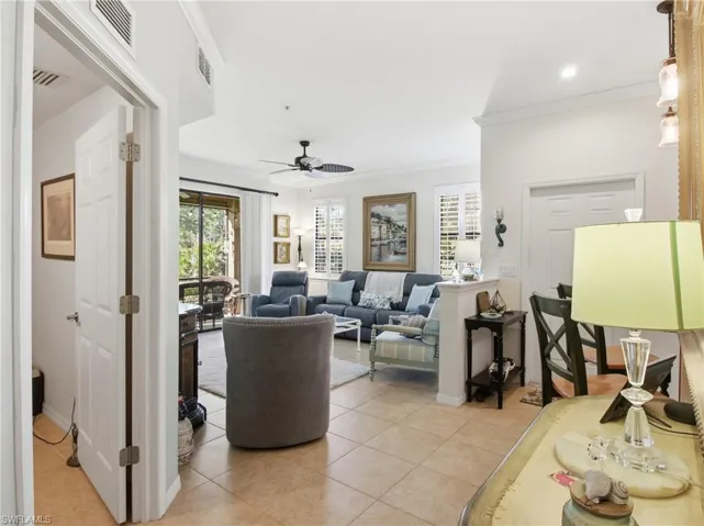 Living area with ornamental molding, plenty of natural light, a ceiling fan, and light tile patterned floors