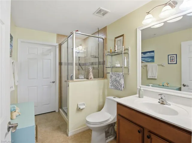 Full bathroom with vanity, a stall shower, and light tile patterned floors