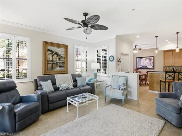 Living area featuring ornamental molding, ceiling fan, and light tile patterned floors