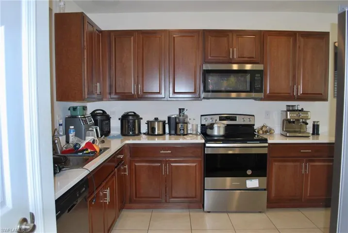 Kitchen featuring stainless steel appliances, light countertops, and light tile patterned floors