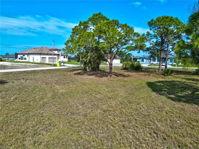 View of grassy yard featuring a garage