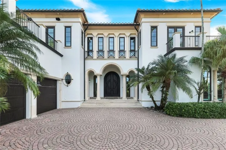 Mediterranean / spanish home featuring stucco siding, a balcony, a garage, and driveway