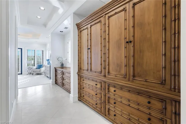 Primary suite with built in cabinetry, recessed lighting, and a tray ceiling