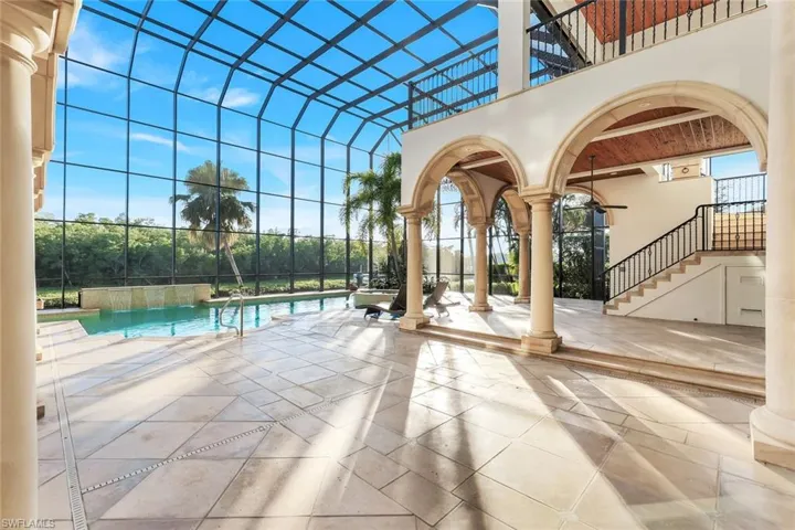 Swimming pool featuring a patio, stairs, a balcony, and a lanai