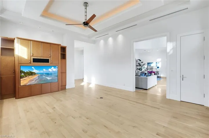 Family room featuring a raised ceiling, built in cabinetry and a ceiling fan