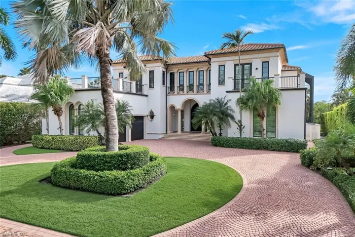 Handsome home featuring curved driveway, stucco siding, a front yard, and a tile roof