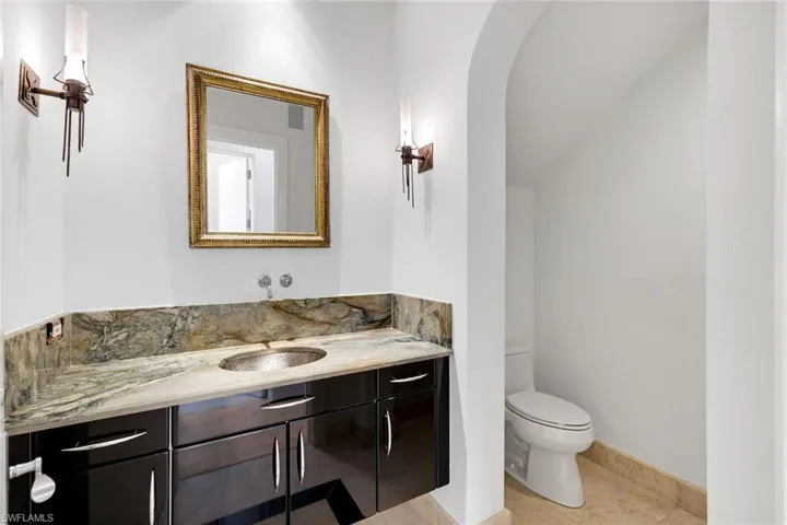 Powder room  with vanity and light tile patterned floors