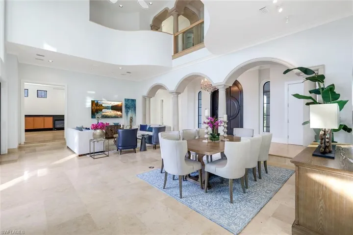 Dining area with arched walkways, decorative columns, and a towering ceiling