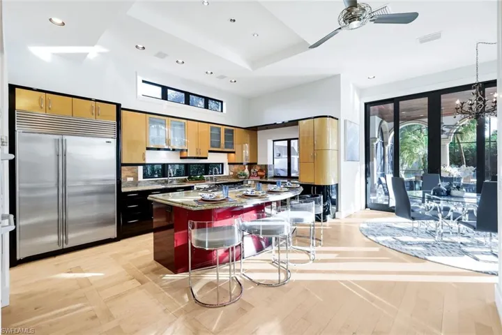 Kitchen featuring stainless steel built in refrigerator, a center island, a kitchen breakfast bar, recessed lighting, and a chandelier
